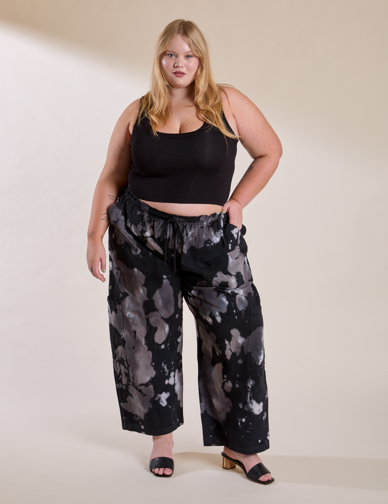 Juliet is 5'7" and wearing 1XL Magic Waters Drop Pocket Pants in Ink Blot paired with a black Cropped Tank