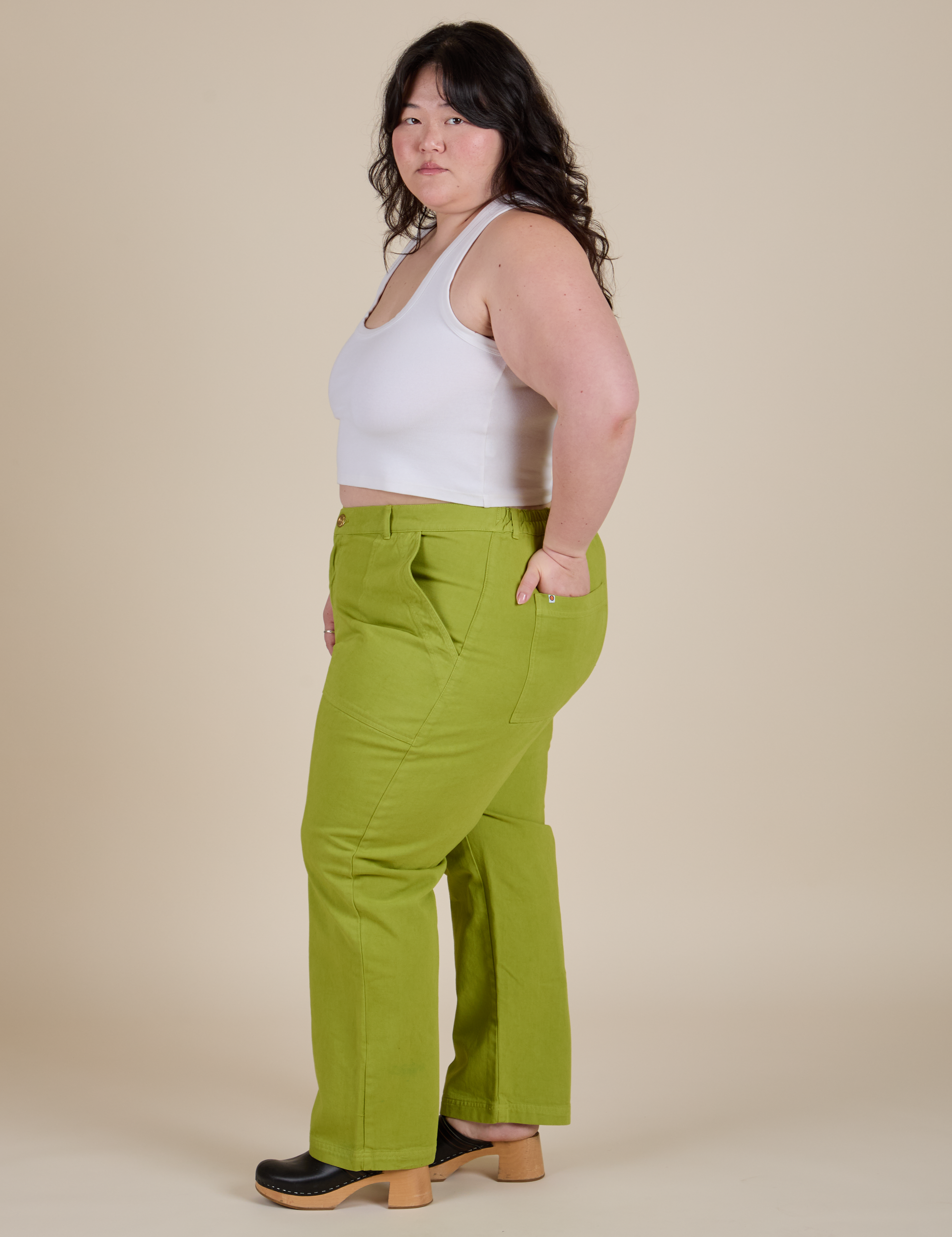 Side view of Work Pants in Gross Green and Cropped Tank in Vintage Tee White on Ashley