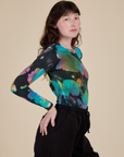 Long Sleeve Baby Tee in Rainbow Magic Waters side view on Alex