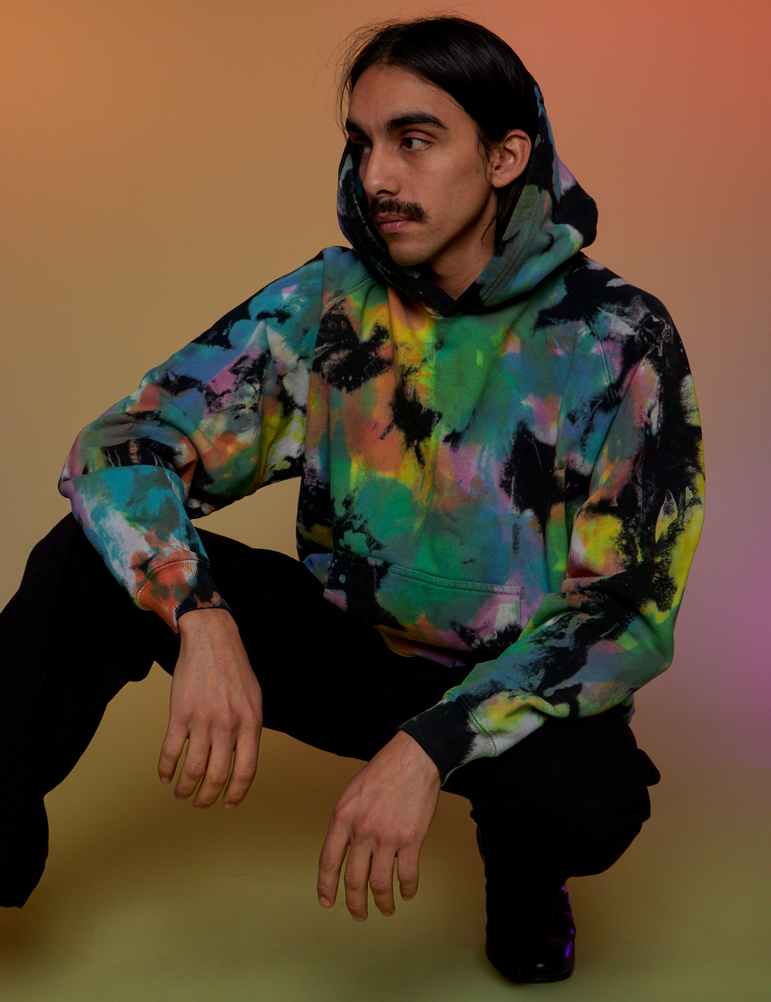 Anthony is wearing Oversized Hoodie in Rainbow Magic Waters