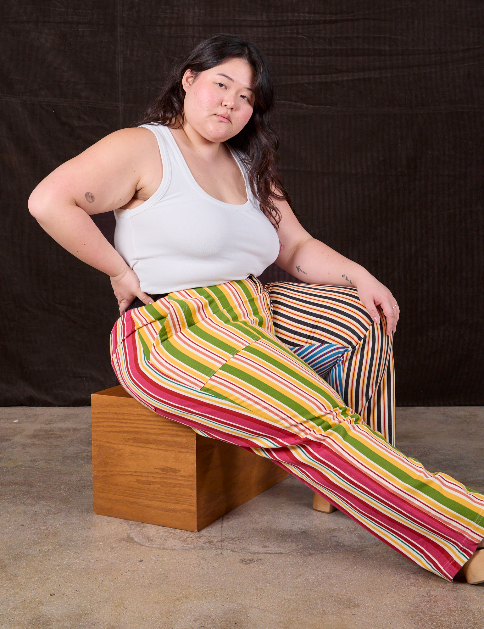 Mixed Stripe Work Pants worn by Ashley sitting on a wooden box