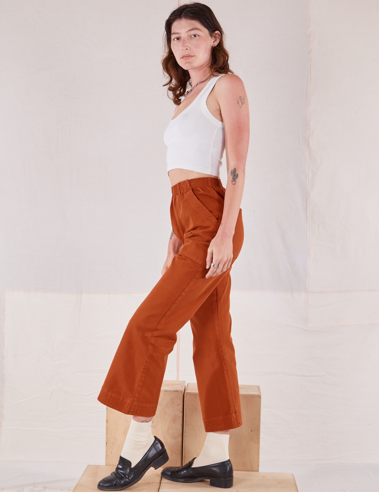 Side view of Action Pants in Burnt Terracotta and Cropped Tank in vintage tee off-white worn by Alex