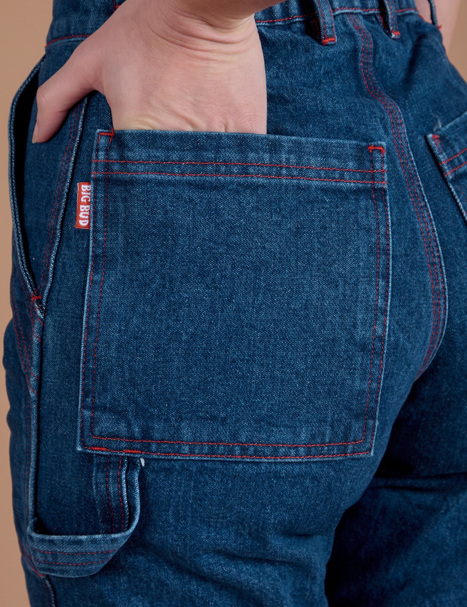 Close up of Alex's hand in the back pocket of Carpenter Jeans in Dark Wash