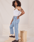 Side view of Carpenter Jeans in Light Wash and Cropped Cami in vintage tee off-white worn by Jesse