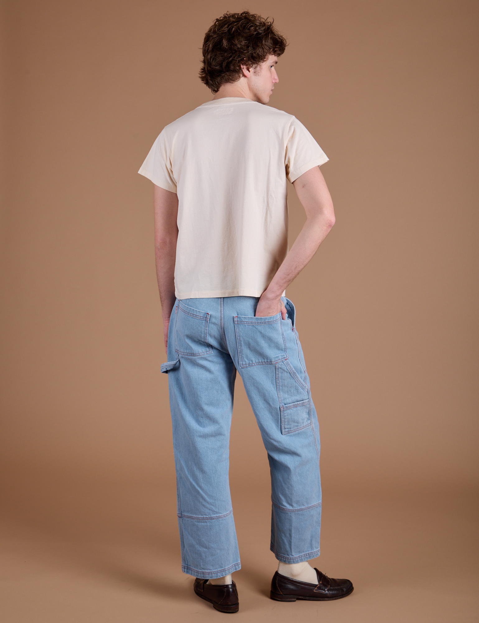 Back view of Carpenter Jeans in Light Wash and Organic Vintage Tee in Vintage Tee Off-White on Quinn