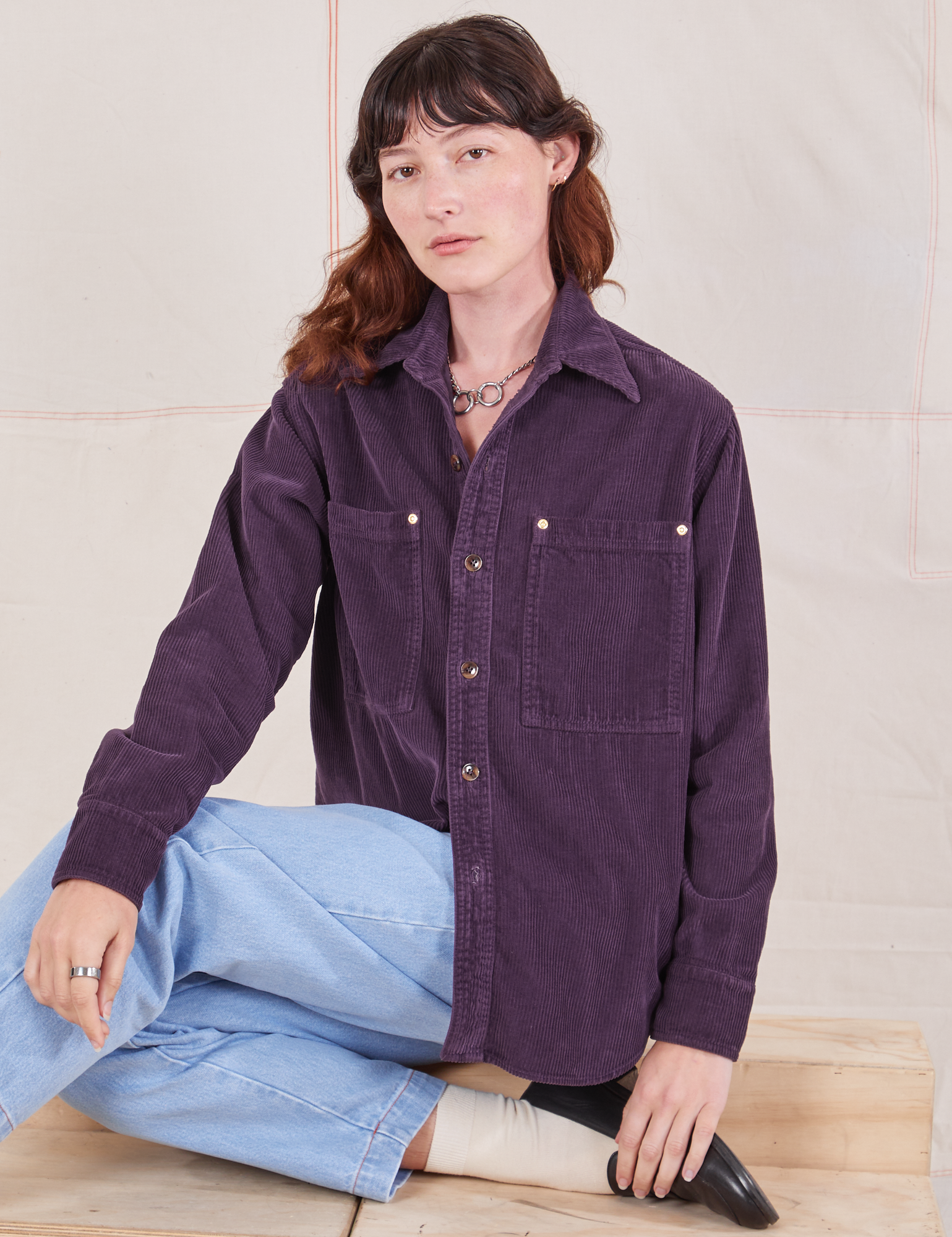 Alex is wearing a buttoned up Corduroy Overshirt in Nebula Purple