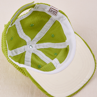 Dugout Corduroy Hat in Gross Green flipped over. White satin under-bill