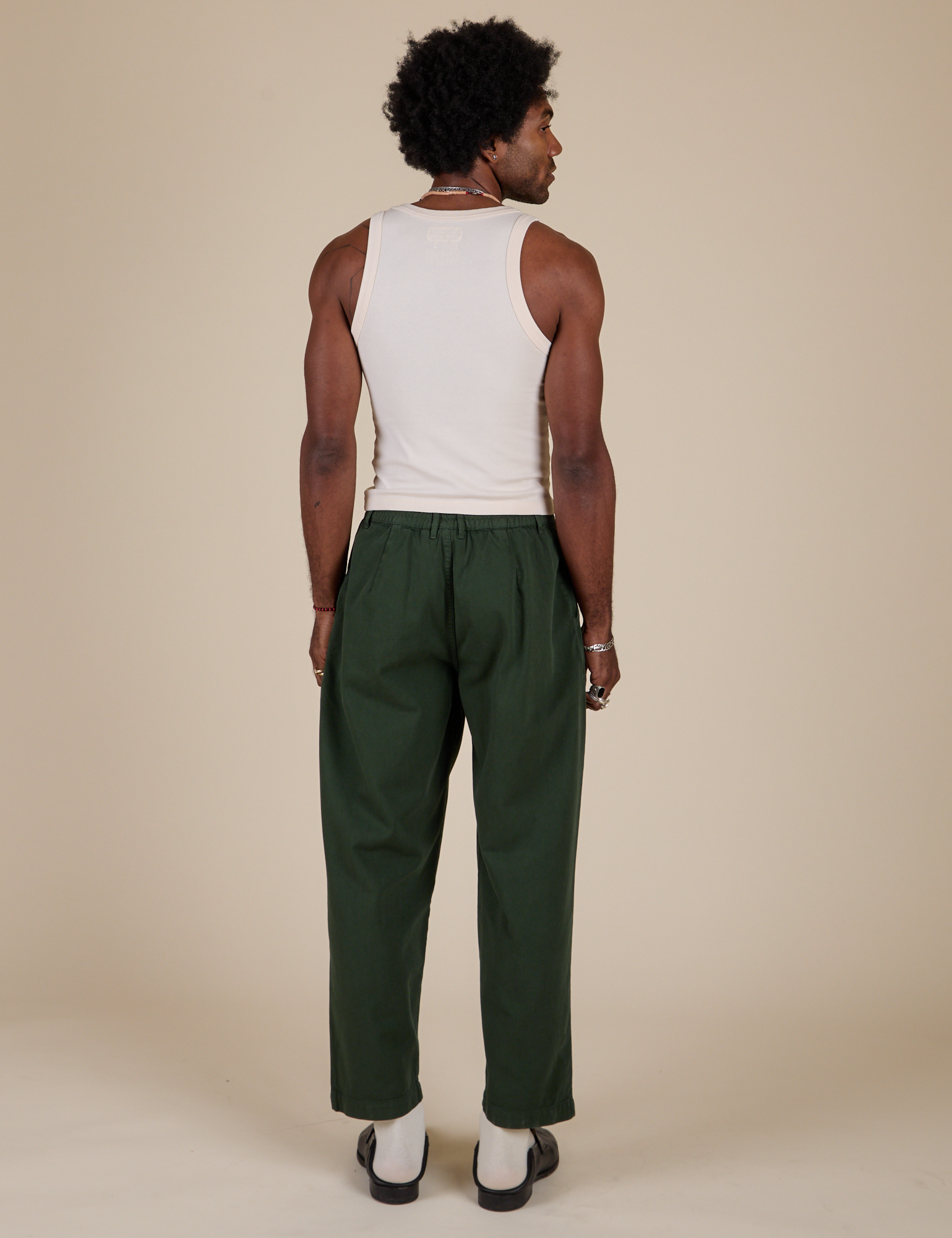 Back view of Heavyweight Trousers in Swamp Green and Tank Top in Vintage Tee Off-White on Jerrod