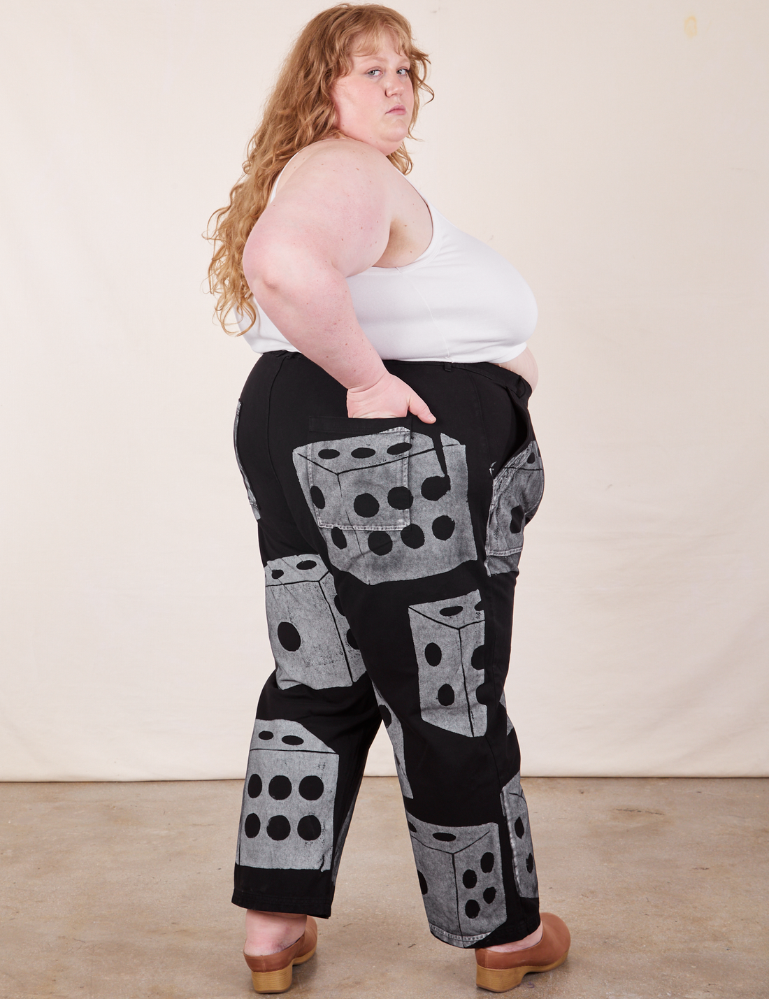 Angled back view of Icon Work Pants in Dice and vintage off-white Cropped Cami worn by Catie