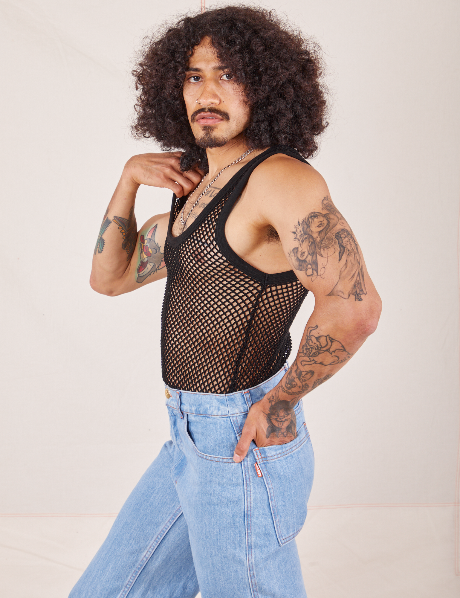 Side view of Mesh Tank Top in Basic Black and light wash Sailor Jeans worn by Jesse