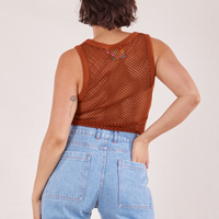 Back view of Mesh Tank Top in Burnt Terracotta and light wash Sailor Jeans. Tiara has her hand in the back pant pocket.