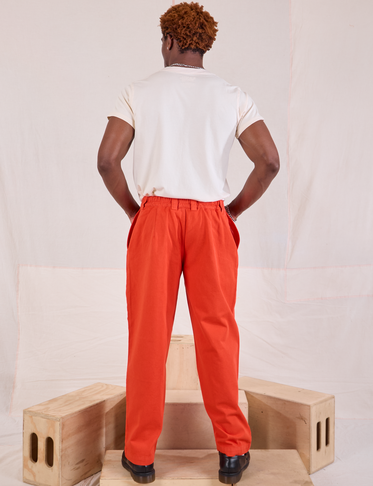 Back view of Mid-Rise Pleated Trousers in Chili Red and Organic Vintage Tee in vintage tee off-white on Issac