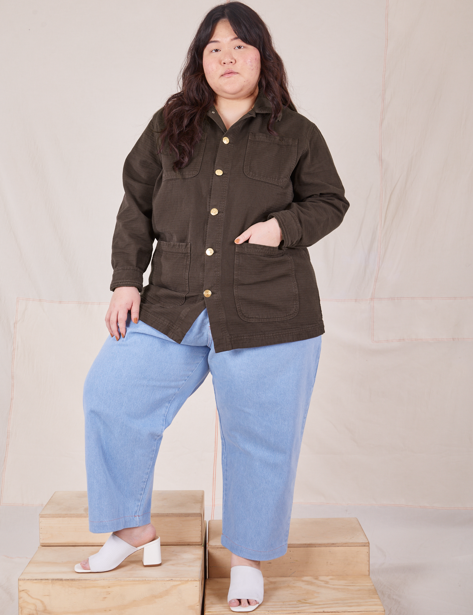 Ashley is wearing a buttoned up Field Coat in Espresso Brown paired with light wash Trouser Jeans
