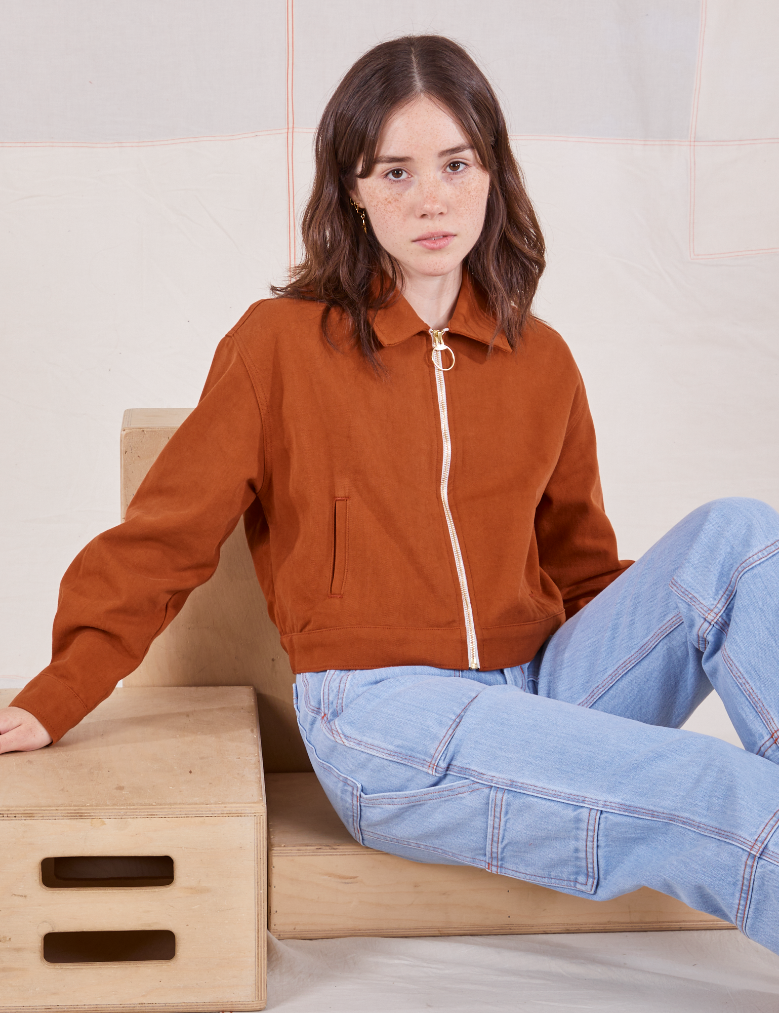 Hana is wearing Ricky Jacket in Burnt Terracotta and light wash Carpenter Jeans