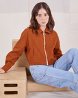 Hana is wearing Ricky Jacket in Burnt Terracotta and light wash Carpenter Jeans