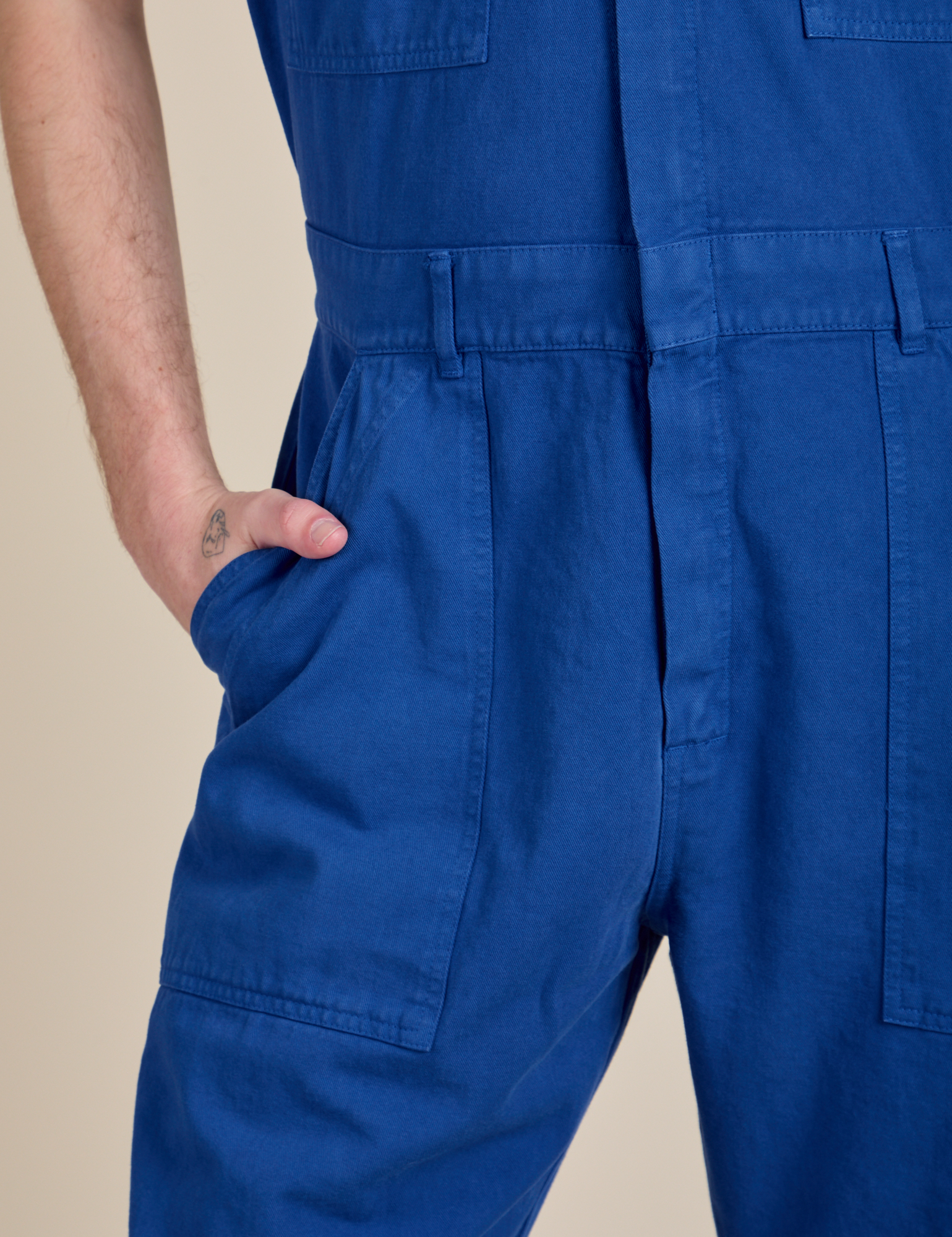 Close up of Quinn's hand in the front pocket of Short Sleeve Jumpsuit in Royal Blue