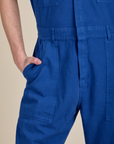 Close up of Quinn's hand in the front pocket of Short Sleeve Jumpsuit in Royal Blue