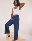 Jerrod is wearing Indigo Wide Leg Trousers in Dark Wash and vintage off-white Cropped Tank Top