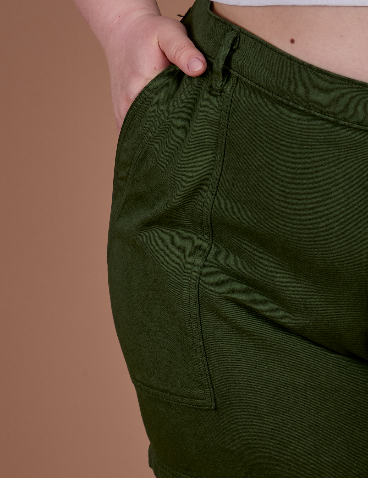 Close up of Ashley's hand in the front pocket of Classic Work Shorts in Evergreen