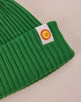 Ribbed Beanie in Forest Green close up of sun baby tag