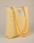 Angled view of Over-Shoulder Zip Mini Tote in Butter Yellow