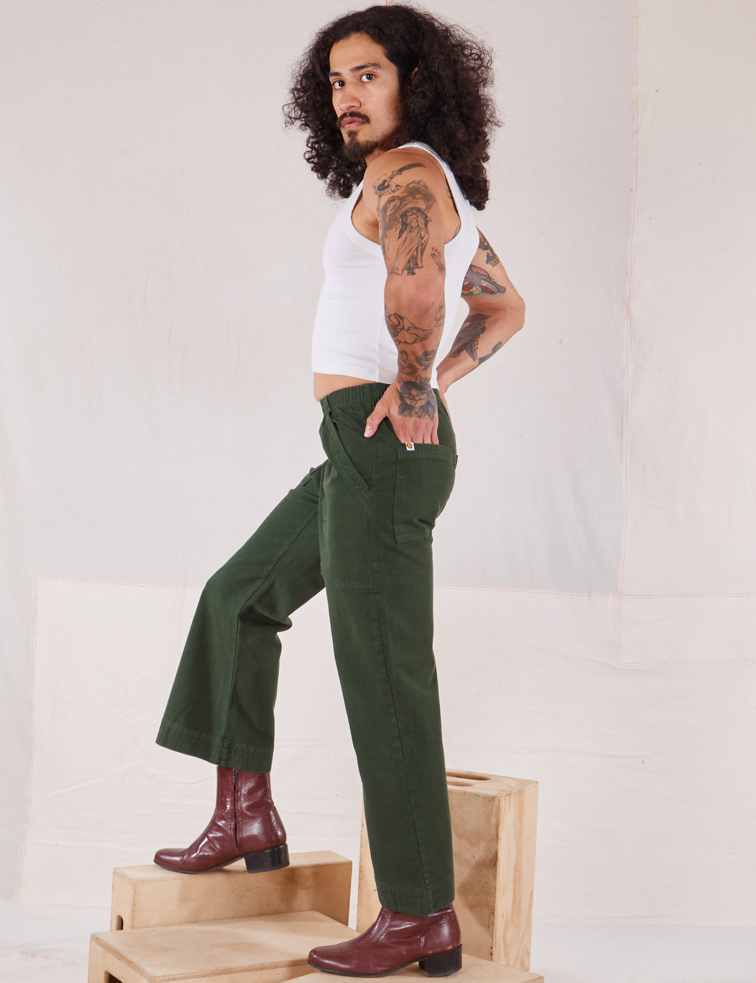 Side view of Action Pants in Swamp Green and Cropped Tank in vintage tee off-white worn by Jesse