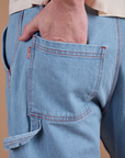 Close up of Quinn's hand in the back pocket of Carpenter Jeans in Light Wash