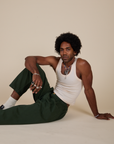 Jerrod is wearing Heavyweight Trousers in Swamp Green and Tank Top in Vintage Tee Off-White
