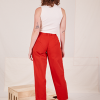 Back view of Heavyweight Trousers in Mustang Red and vintage off-white Sleeveless Turtleneck worn by Alex