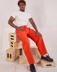 Issac is wearing Mid-Rise Pleated Trousers in Chili Red and Organic Vintage Tee in vintage tee off-white