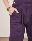 Front pocket close up of Original Overalls in Mono Nebula Purple. Hana has her hand in the pocket.