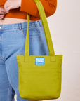 Over-Shoulder Zip Mini Tote in Gross Green worn on arm of model