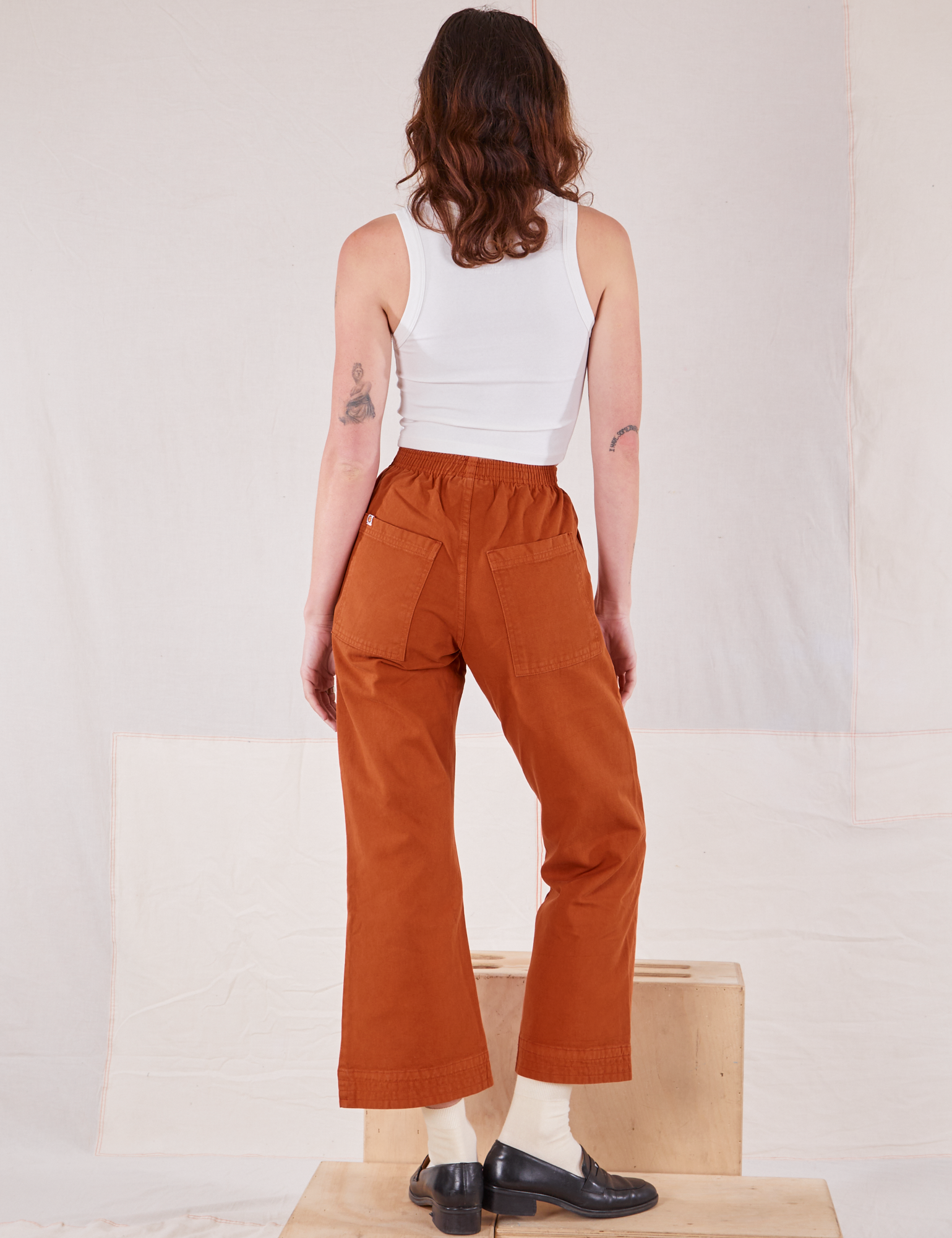 Back view of Action Pants in Burnt Terracotta and Cropped Tank in vintage tee off-white worn by Alex