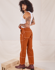 Angled back view of Carpenter Jeans in Burnt Terracotta on Jesse