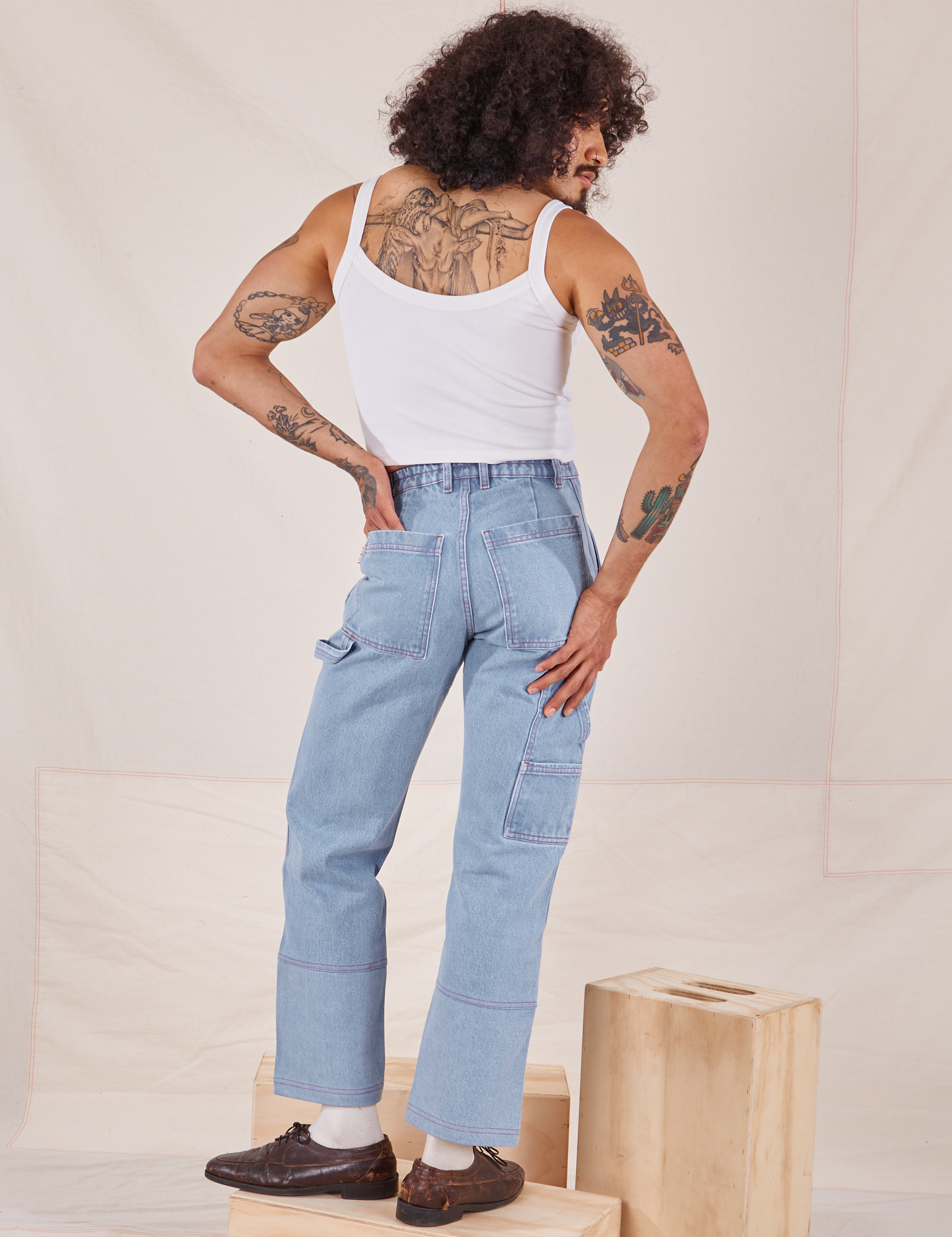 Back view of Carpenter Jeans in Light Wash and Cropped Cami in vintage tee off-white worn by Jesse