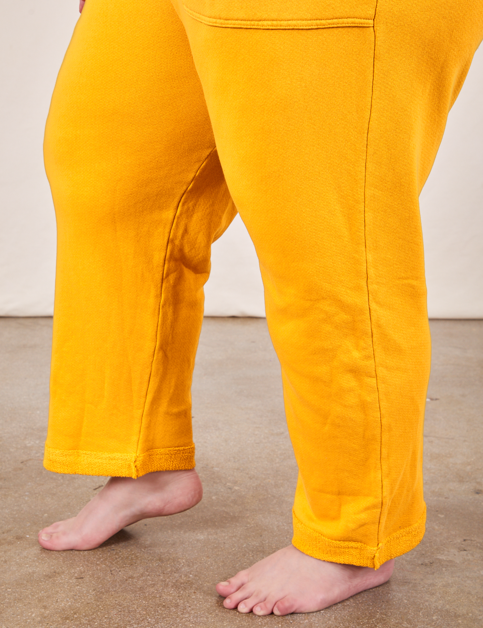 Cropped Rolled Cuff Sweatpants in Mustard Yellow pant leg side view on Marielena