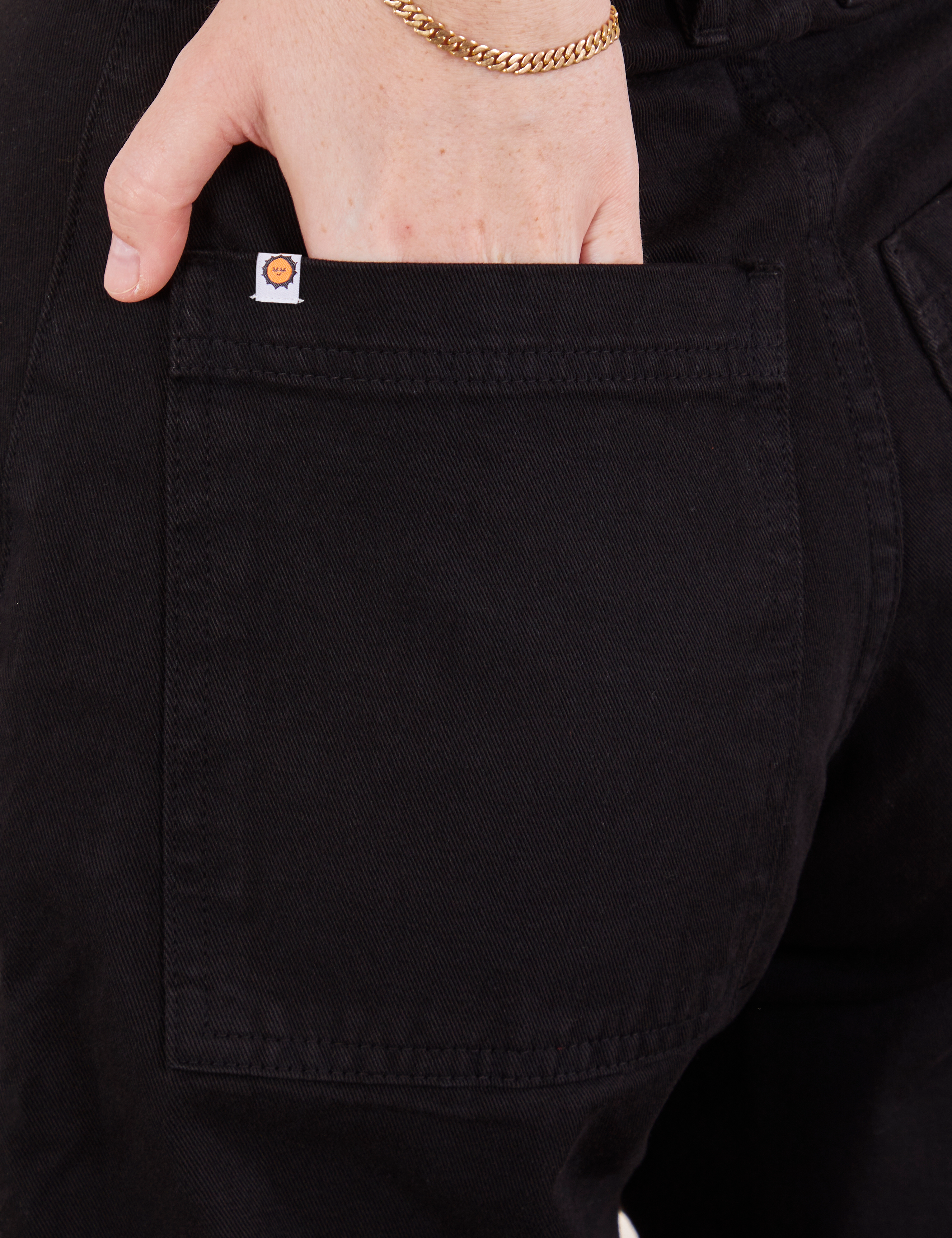 Petite Pencil Pants in Basic Black back pocket close up. Hana has her hand in the pocket.