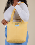 Over-Shoulder Zip Mini Tote in Butter Yellow worn on shoulder of model