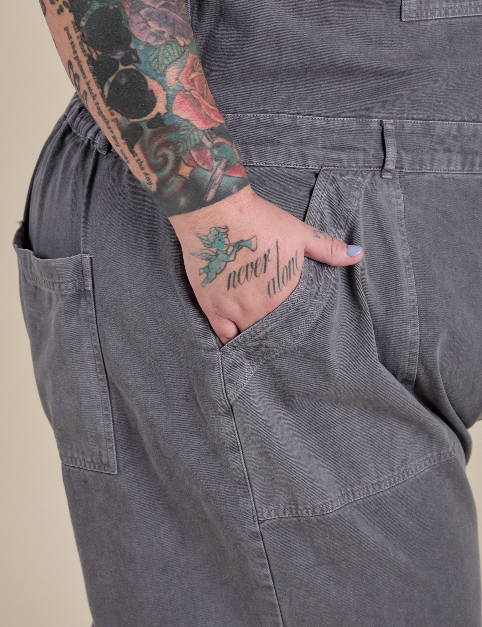 Close up of Sam's hand in the front pocket of Short Sleeve Jumpsuit in Washed Grey