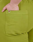 Close up of Ashley's hand in the back pocket of Work Pants in Gross Green