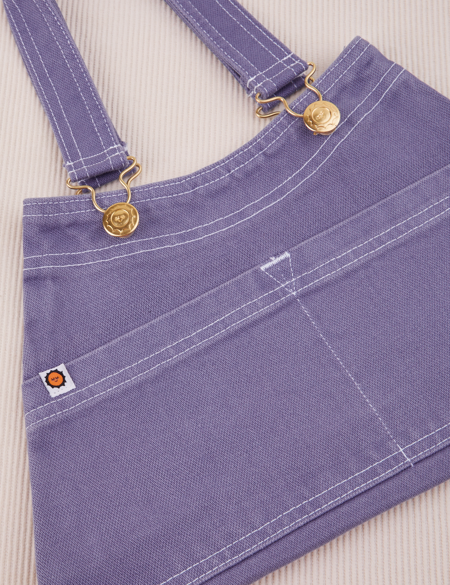 Overall Handbag in Faded Grape. White contrast stitching. Brass sun baby buttons and hardware.