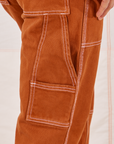 Carpenter Jeans in Burnt Terracotta pant leg close up of contrast white topstitching. 