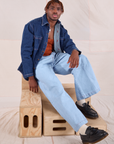 Issac is wearing Denim Overshirt in Dark Wash and light wash Wide Leg Denim Trousers