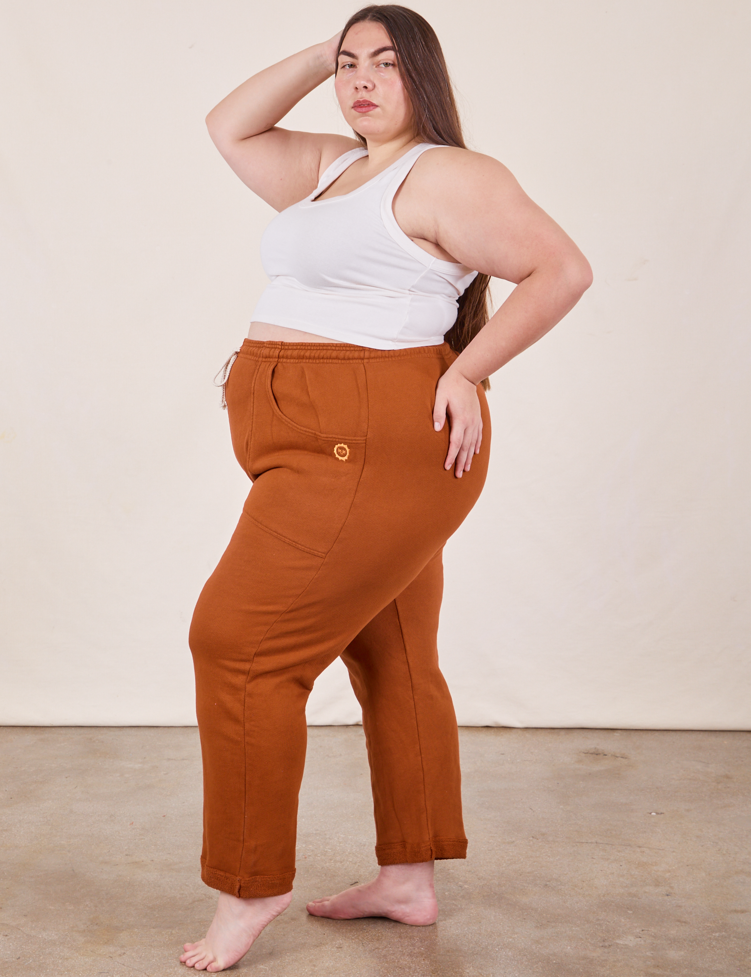 Side view of Cropped Rolled Cuff Sweatpants in Burnt Terracotta and vintage off-white Cropped Tank Top on Marielena