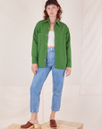 Alex is wearing Oversize Overshirt in Lawn Green, vintage off-white Tank Top and light wash Frontier Jeans