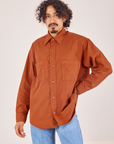 Jesse is wearing a buttoned up Oversize Overshirt in Burnt Terracotta