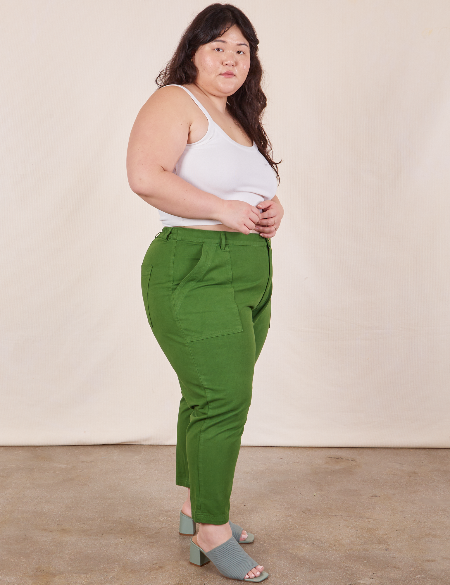 Side view of Petite Pencil Pants in Lawn Green and vintage off-white Cropped Cami on Ashley