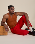 Racerback Tank in Burnt Terracotta and mustang red Work Pants on Isaac