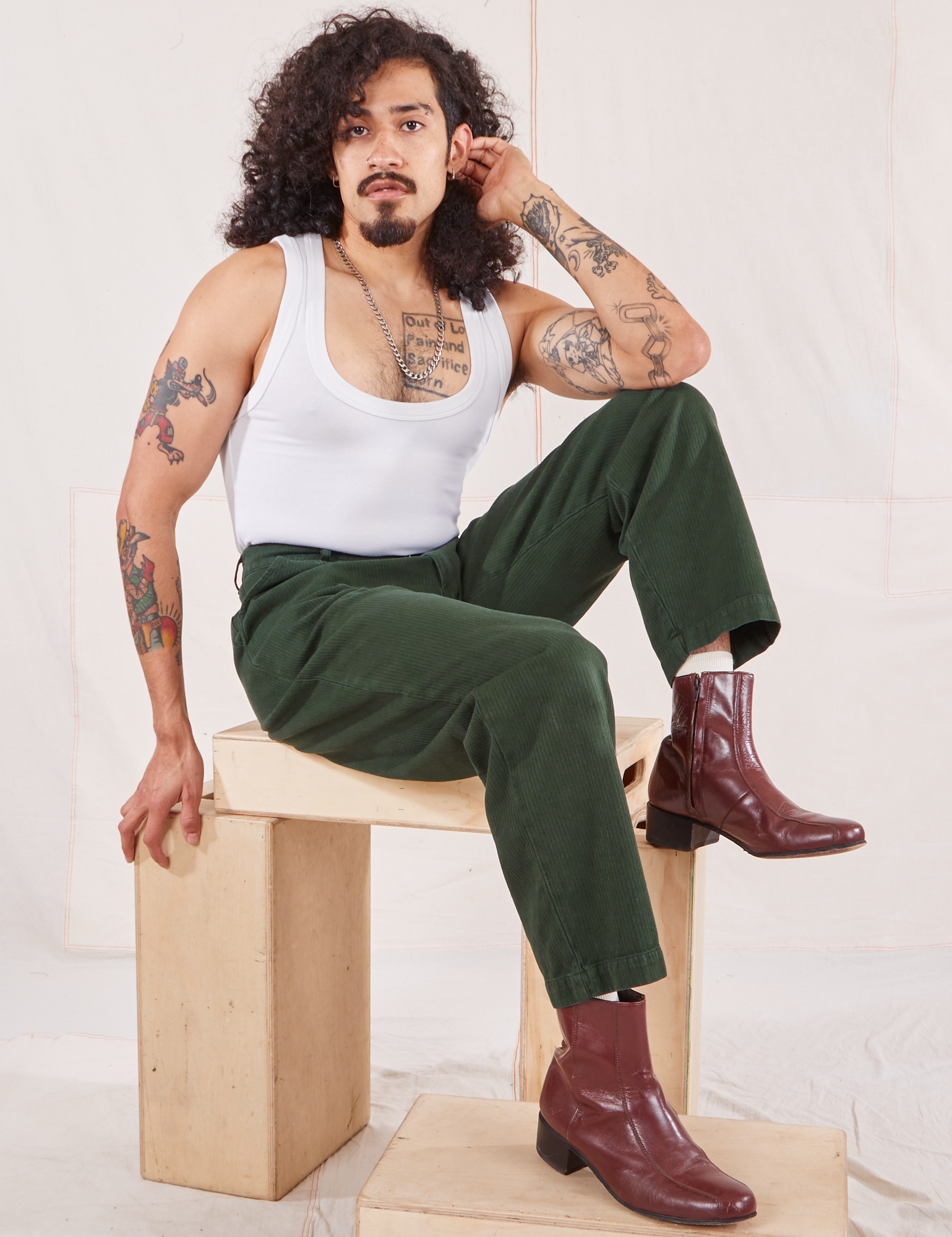 Jesse is wearing Heritage Trousers in Swamp Green and vintage off-white Tank Top