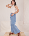 Side view of Indigo Wide Leg Trousers in Light Wash and vintage off-white Sleeveless Turtleneck
